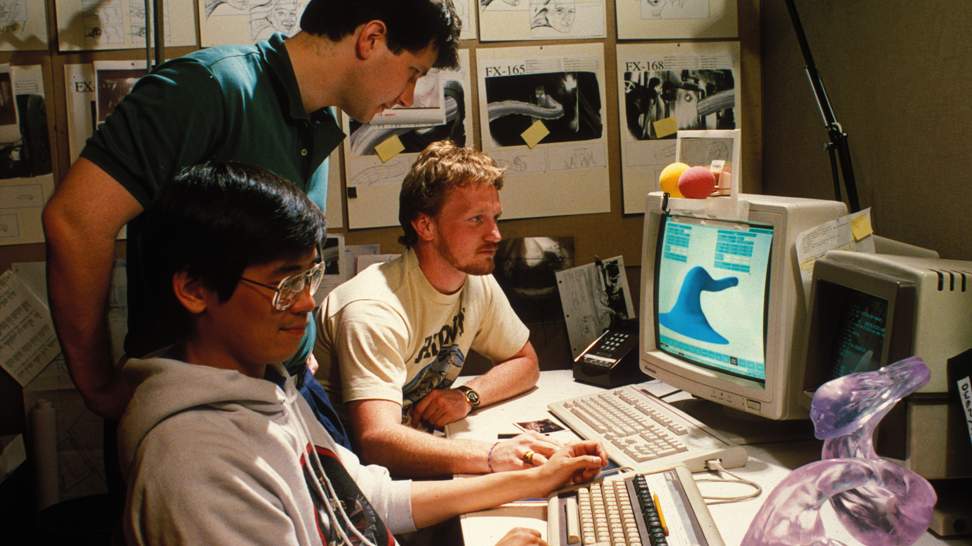 John Knoll (Standing), Lincoln Hu (left) and Scott E. Anderson work on the computer generated pseudopod water tentacle for James Cameron’s The Abyss (1989). © Industrial Light & Magic. All Rights Reserved