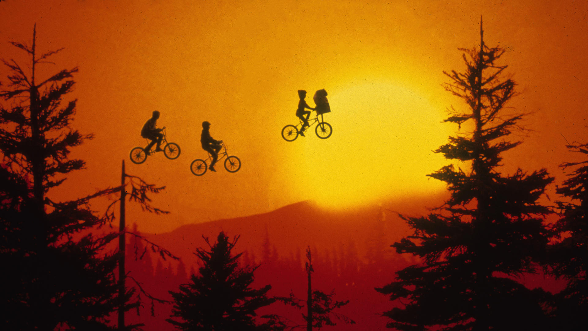 E.T., Elliot, and his friends take flight in this shot from E.T. the Extra-Terrestrial (1982) achieved in-camera utilizing miniature puppets, trees and a matte painting backdrop. © Industrial Light & Magic. All Rights Reserved
