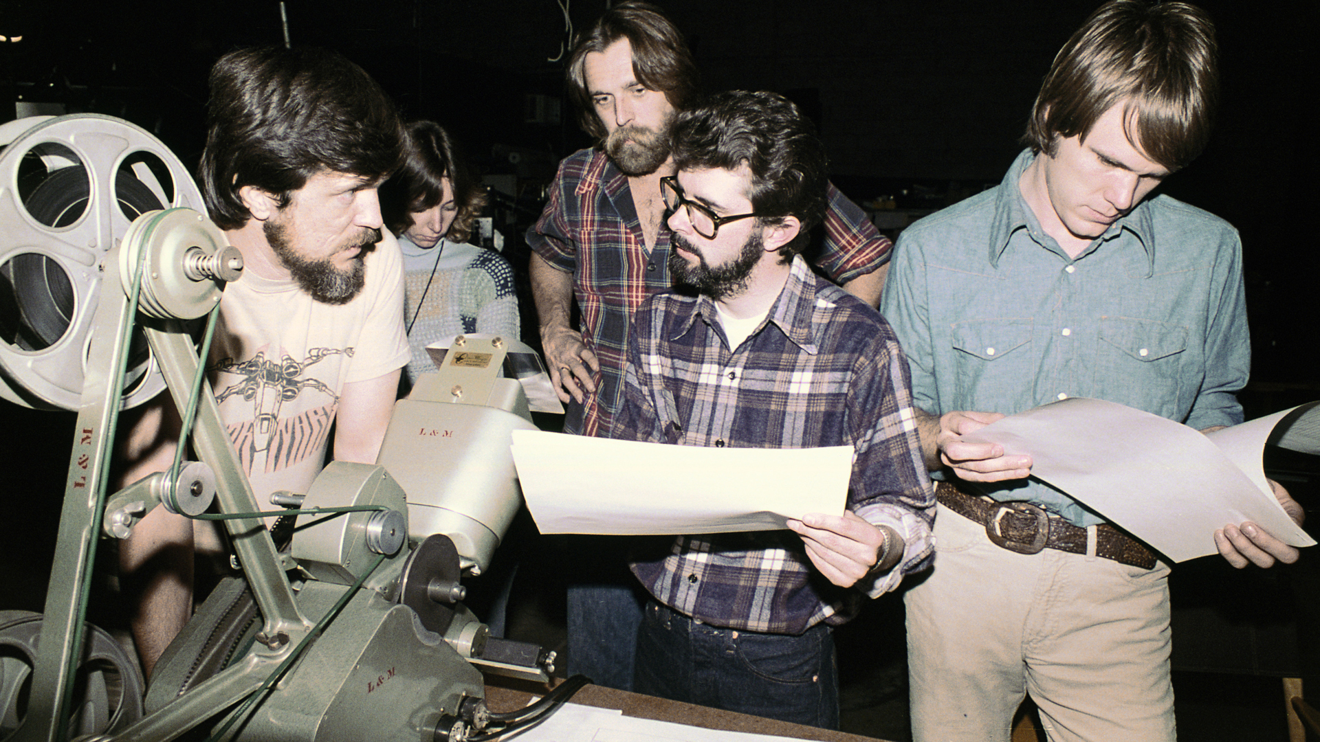 Richard Edlund, Rose Duginan, John Dykstra, George Lucas and Joe Johnston review storyboards during visual effects production on Star Wars (1977). © Industrial Light & Magic. All Rights Reserved